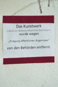 Kunst zur Kanalisierung menschlicher Bedürfnisse in Hildesheim Hinweisschild